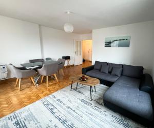 een woonkamer met een bank en een tafel bij EXIGEHOME - Grand T4 en centre ville à 10 min du RER A in Maisons-Laffitte