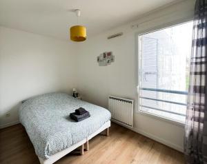 - une chambre avec un lit et une grande fenêtre dans l'établissement EXIGEHOME - Grand T4 en centre ville à 10 min du RER A, à Maisons-Laffitte