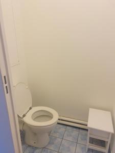 La salle de bains est pourvue de toilettes blanches et d'un tabouret. dans l'établissement EXIGEHOME - Grand T4 en centre ville à 10 min du RER A, à Maisons-Laffitte
