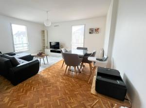 een woonkamer met een tafel en stoelen bij EXIGEHOME - Grand T4 en centre ville à 10 min du RER A in Maisons-Laffitte