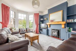uma sala de estar com um sofá e uma lareira em Braeside - 4 Beds - Sleeps 8 - Garden em St. Andrews