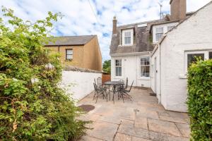a patio with chairs and a table in a house at Braeside - 4 Beds - Sleeps 8 - Garden in St Andrews