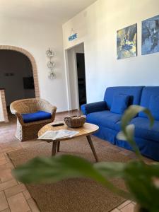 a living room with a blue couch and a table at Sea Breeze House in Fiumicino