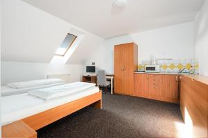 2 Betten in einem Zimmer mit Küche in der Unterkunft Penzion U Gigantu in Pilsen