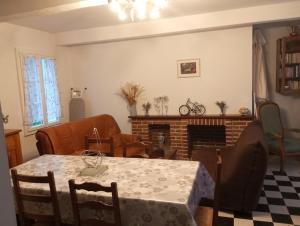 un soggiorno con tavolo e camino di maison des papillons a Tourville-la-Chapelle