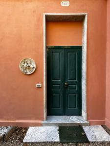 eine grüne Tür an einer orangefarbenen Wand in der Unterkunft Villa San Giorgio vista mare Alassio in Alassio