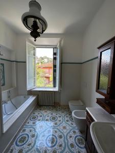 ein Bad mit einer Badewanne, 2 WCs und einem Fenster in der Unterkunft Villa San Giorgio vista mare Alassio in Alassio