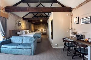 1 dormitorio con 1 cama y 1 sofá azul en The Lobster en Sheringham