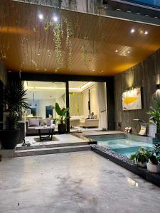 a swimming pool in a house with a living room at DELUXE VILLA 4 phòng ngủ 5 giường lớn in Hue