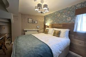 a bedroom with a large bed and a chandelier at The Lobster in Sheringham