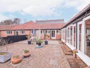 ein Innenhof eines Hauses mit Topfpflanzen in der Unterkunft Avocet Cottage in Saxmundham