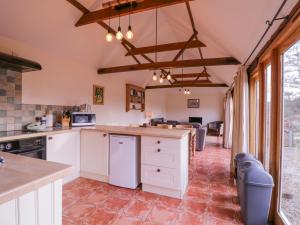 a kitchen with white cabinets and a large window at Avocet Cottage in Saxmundham