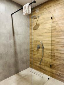 y baño con ducha y puerta de cristal. en Фільварок Кмитів, en Kosharishche