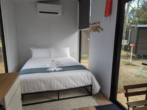 a bedroom with a bed with a bird sitting on it at Tiny House 14B at Grampians Edge in Dadswells Bridge