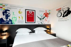 a bedroom with a bed and posters on the wall at Hotel Football, Old Trafford, a Tribute Portfolio Hotel in Manchester