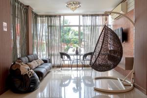 a living room with a couch and a hanging chandelier at The Infinity Suite Chiangrai in Chiang Rai
