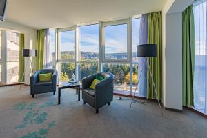a room with two chairs and a table and windows at Ringberg Hotel in Suhl