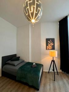 1 dormitorio con cama y lámpara de araña en Wohnung im Zentrum 1, en Magdeburgo