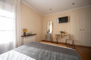 a bedroom with a bed and a tv on the wall at Hotel Siuranella in Siurana