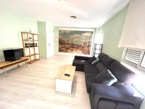 ein Wohnzimmer mit einem Sofa und einem Tisch in der Unterkunft Barrio San Miguel Más que apartamentos in Murcia