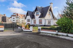 uma grande casa branca com um telhado preto em Lucky em Sint-Idesbald