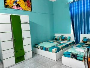Công ty TNHH Khách sạn Lê Phan في Cu Chi: سريرين في غرفة بجدران زرقاء