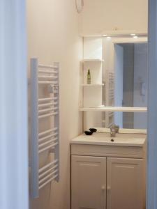y baño con lavabo y espejo. en Joli appartement à Lannion, en Lannion