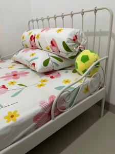 Una cama con flores y un animal de peluche. en Breeze House en Prampuan