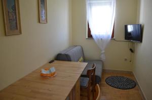 un soggiorno con un tavolo e un divano di Apartments Aneva 1 a Baška