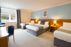 Habitación de hotel con 2 camas y sofá en Hotel Ceann Sibeal en Dingle