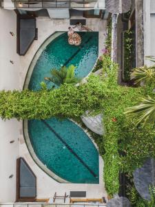an overhead view of a swimming pool with green plants at Sini Vie Villa Seminyak by Ini Vie Hospitality in Seminyak