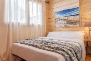 uma cama num quarto de madeira com uma janela em Bungalow Oslo em L'Escala