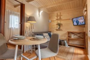 uma sala de jantar com uma mesa e cadeiras e um sofá em Bungalow Oslo em L'Escala