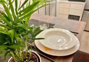 a white plate sitting on a table with plants at Wohnung für 1-2 Personen - Zu Fuß zur Messe - mit U-Bahn in die City in Nuremberg