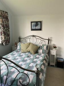 a bedroom with a bed with a blue and white comforter at 2 bedroom Holiday home in Norfolk private field in Wisbech