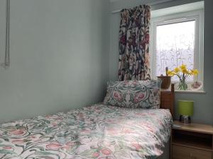 a bedroom with a bed with a floral bedspread and a window at 2 bedroom Holiday home in Norfolk private field in Wisbech