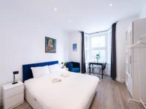 a bedroom with a large white bed and a table at Pass the Keys Kings Cross Urban Escape in London