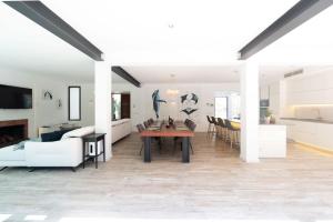 a kitchen and living room with a table and chairs at Casa Guindilla in Portals Nous