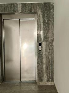 a metal door in a room with a wall at Foleza Studio Apartament-Shengjin in Margjonaj