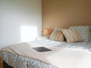 1 dormitorio con 1 cama con ordenador portátil en Joli appartement à Lannion, en Lannion