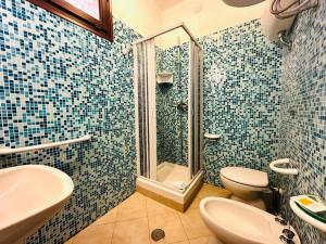 a bathroom with a shower and a toilet and a sink at Residence Hotel La Pelosetta in Stintino