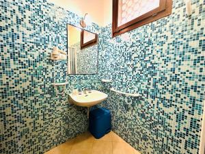 a bathroom with a sink and a mirror at Residence Hotel La Pelosetta in Stintino