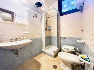 a bathroom with a toilet and a sink and a shower at Residence Hotel La Pelosetta in Stintino