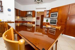 a large kitchen with a wooden table and a counter at Prime Located Home by *The Sea* in Sliema