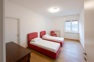 um quarto com duas camas e uma mesa e duas cadeiras em Le Case Di Ferdinando em Lecco