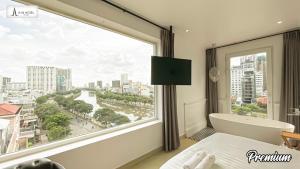 una camera da letto con una grande finestra con vista sulla città di A In Hotel Riverside ad Ho Chi Minh