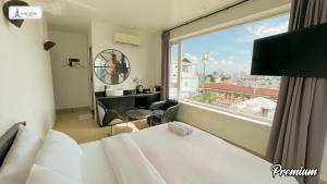 um quarto de hotel com uma cama e uma grande janela em A In Hotel Riverside em Ho Chi Minh