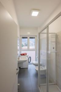 uma casa de banho com 2 WC, um lavatório e um chuveiro em Le Case Di Ferdinando em Lecco