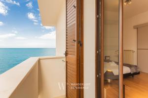 a bedroom with a view of the ocean at Wanderlust Experience Portsea Apartment in Giovinazzo