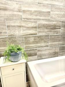 a bathroom with a white tub and a plant on a table at Modernised cottage Sleeps Six in Ore